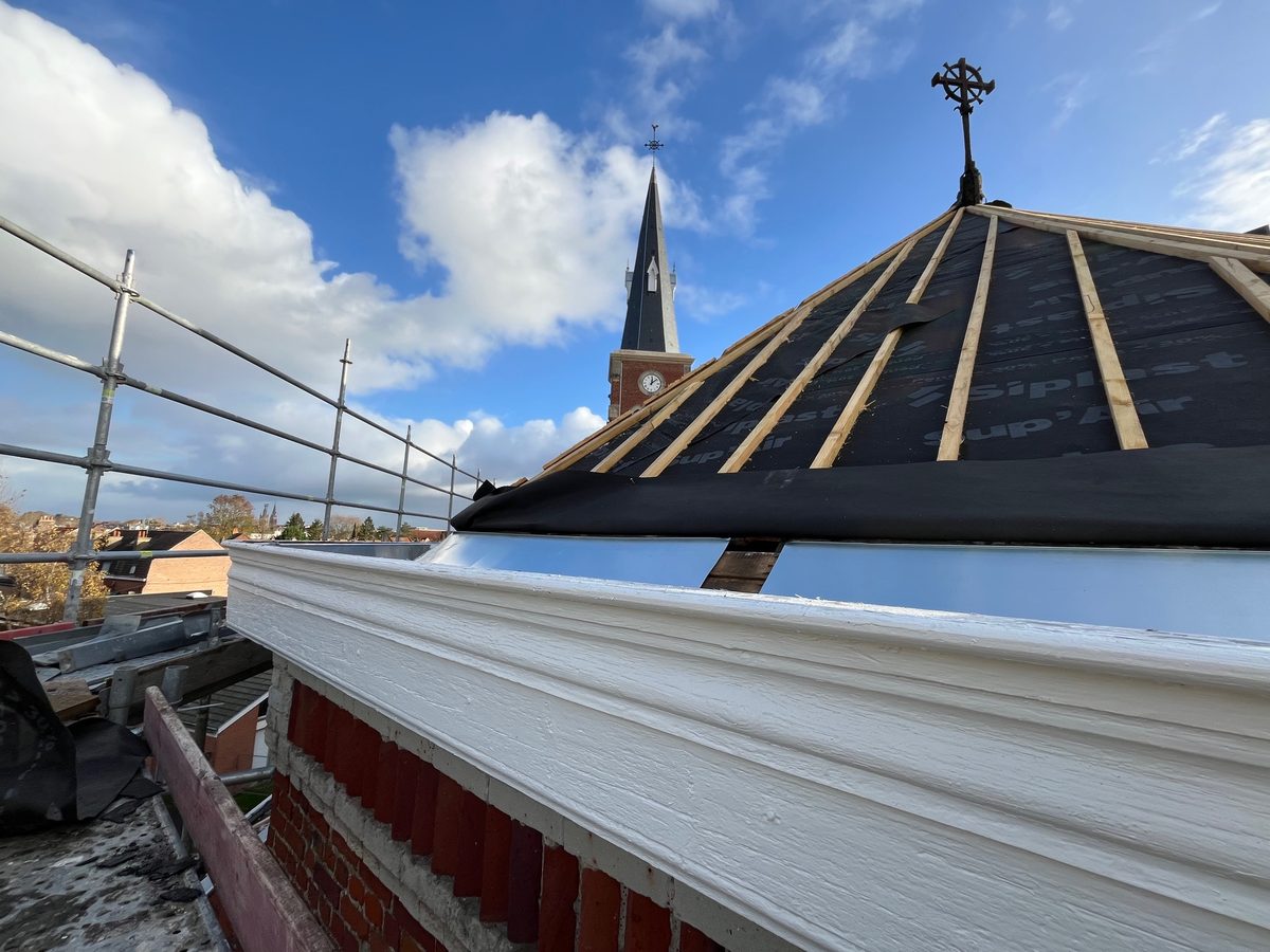 Charpente neuve de la flèche et écran de sous-toiture, clocher en arrière-plan