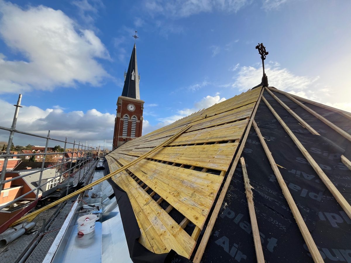 Reprise de charpente et voligeage de la toiture de l'église Notre-Dame de Lourdes, clocher en arrière-plan