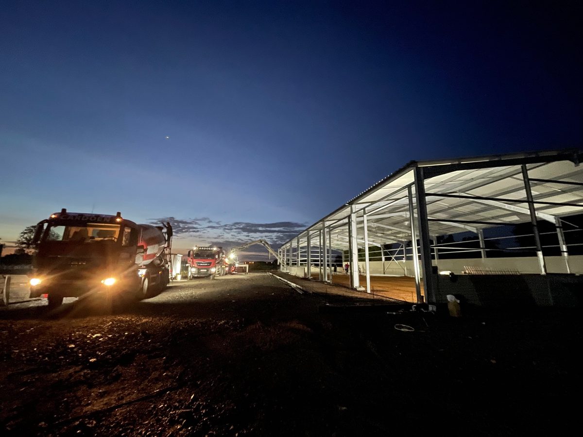 Coulage du dallage béton mené de nuit, toupies en approche