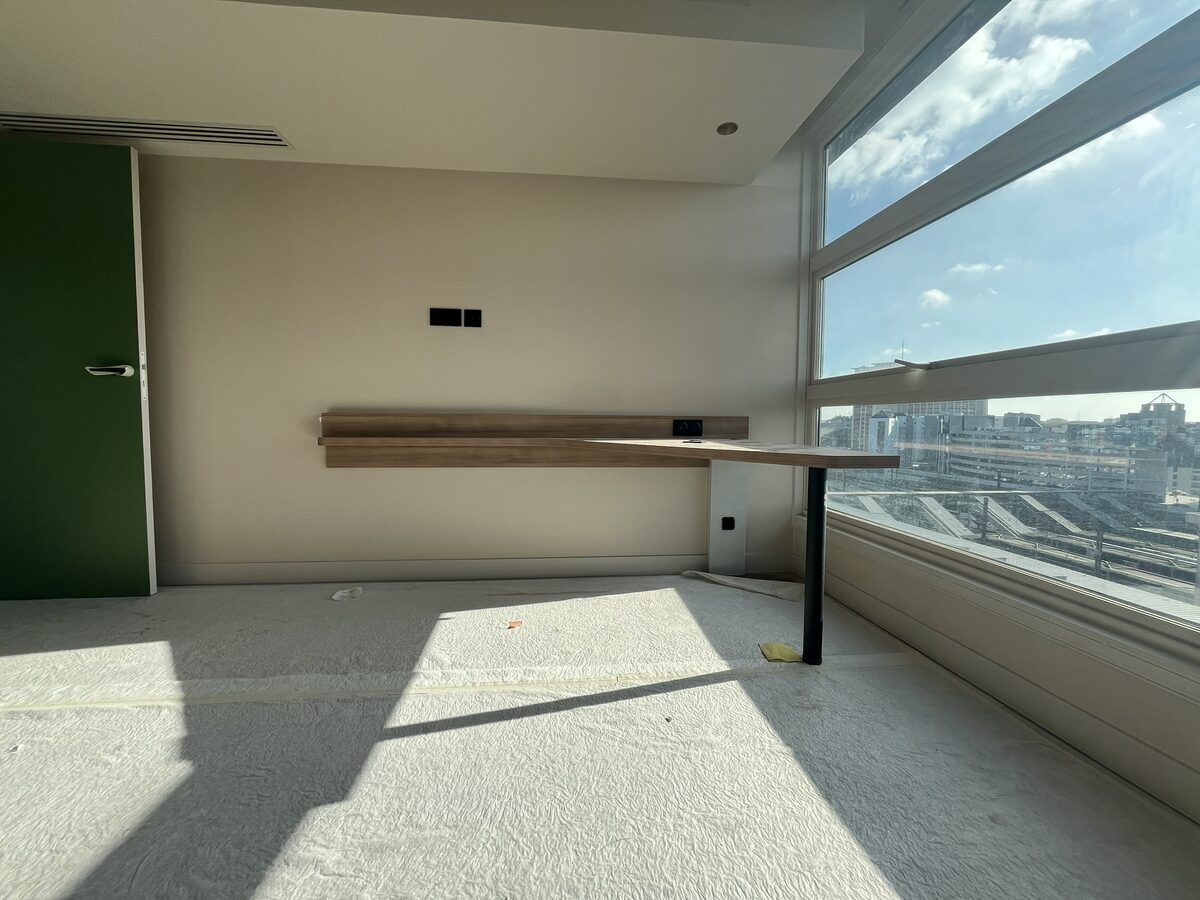 Espace bureau avec plan de travail bois et vue sur les toits parisiens