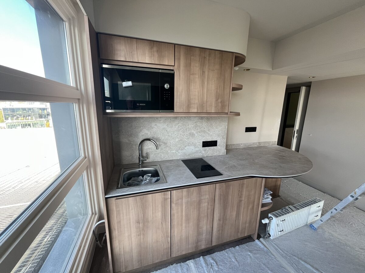 Kitchenette équipée en bois avec micro-ondes et plan de travail