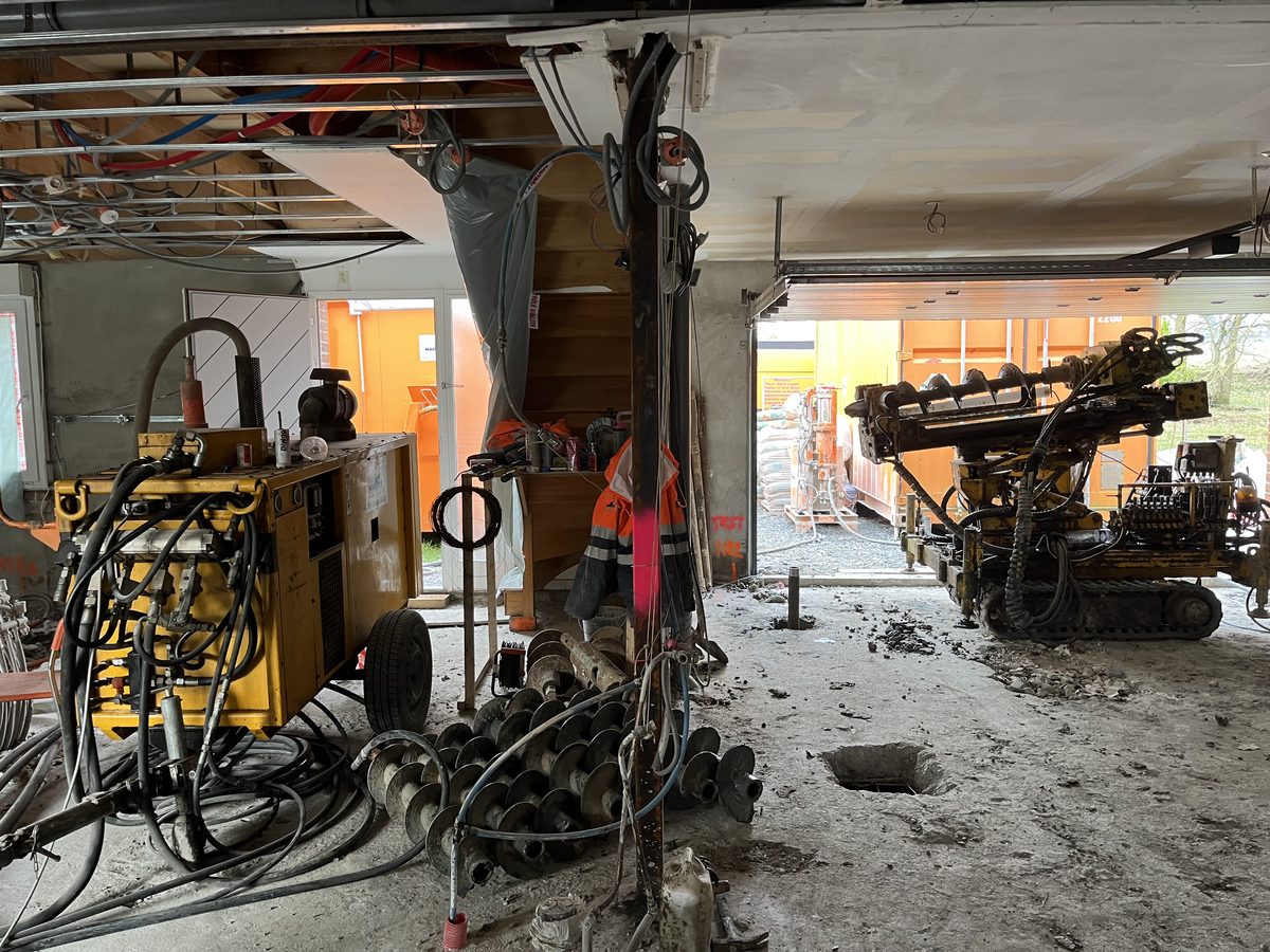 Machines de forage compactes à l'œuvre à l'intérieur du pavillon pour la reprise en sous-œuvre